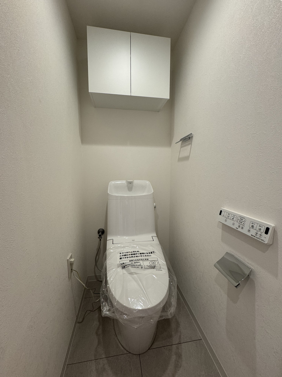 【トイレ】温水洗浄便座が搭載されており、一年中快適にご利用いただけます。吊戸棚が設置されており、トイレットペーパーのストックなどを収納可能です。