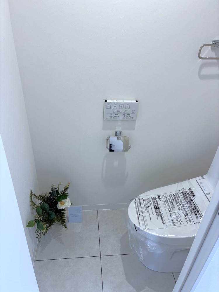 【トイレ】温水洗浄便座付きのトイレです。寒い時期でも暖かな便座で快適に使うことができます。リモコンが壁に設置され、操作しやすい仕様です。
