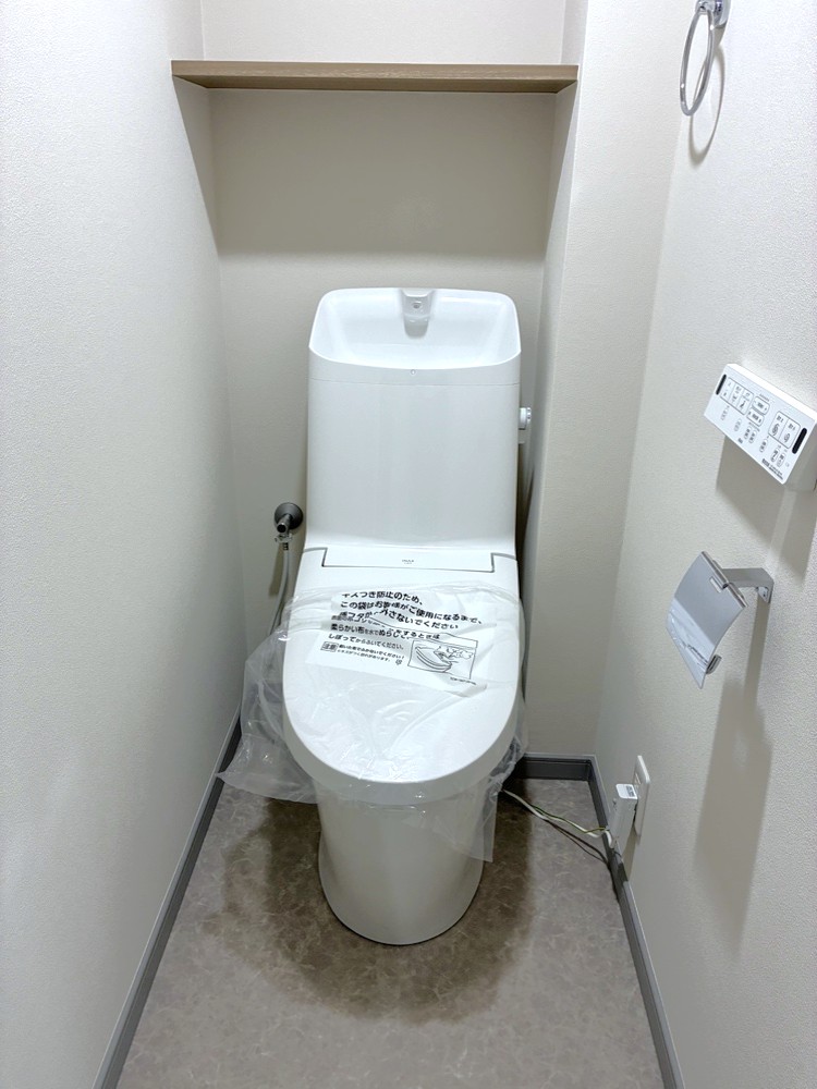【トイレ】温水洗浄便座付きのトイレです。寒い時期でも温かな便座で快適に使うことができます。上部には棚があり、トイレットペーパーの予備や芳香剤を置くことができます。