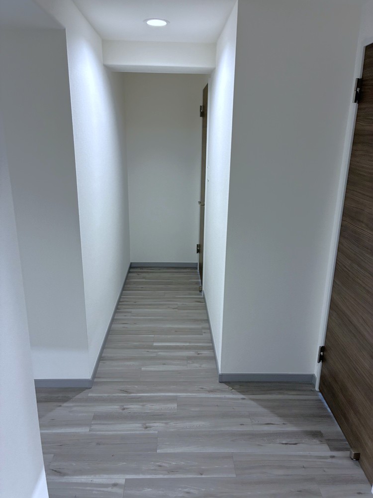 【廊下】落ち着いた色合いの廊下が住まいにやさしい雰囲気を添えています。北側の洋室は振り分けタイプで配置され、プライバシー性と使い勝手の両立に配慮された動線です。