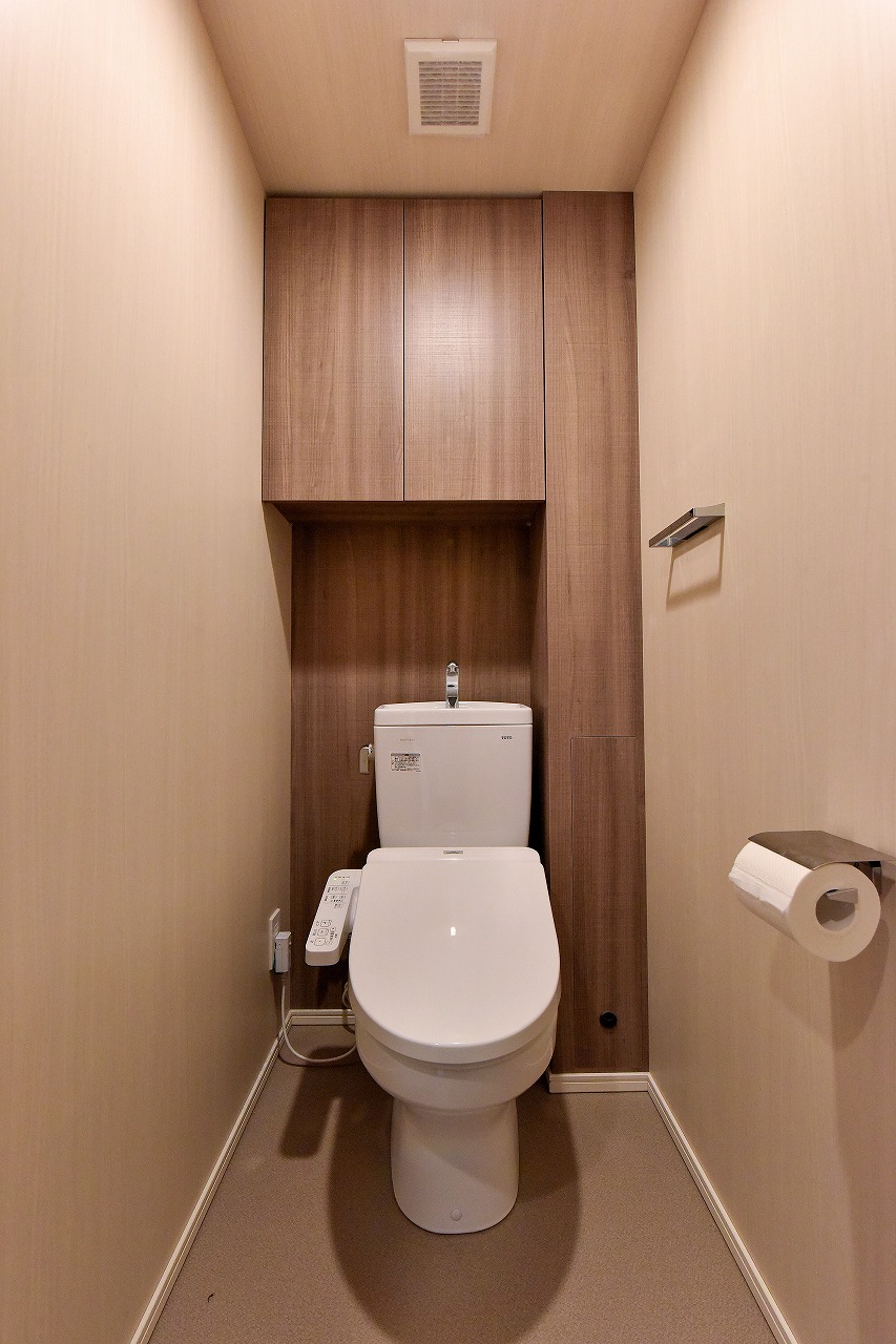 【トイレ】年中快適に利用できる、温水洗浄便座付き。背面には棚が備わり、トイレットペーパーや掃除用具などをまとめて収納可能です。