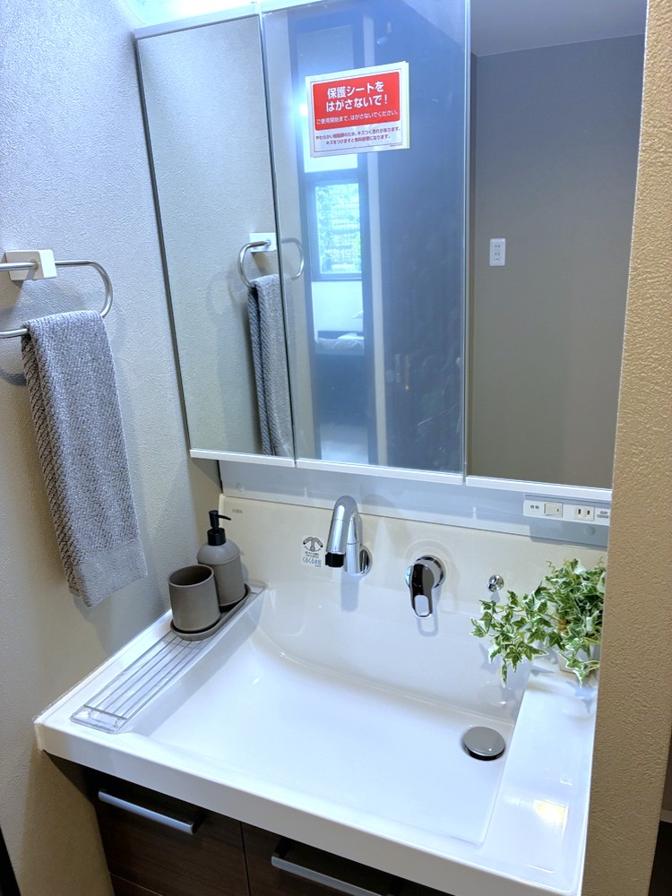 【洗面所】身支度がしやすく、収納力のある三面鏡付き洗面化粧台が備えられています。ボウル下にも収納スペースがあり、ドライヤー・ヘアアイロン等をすっきり収納できます。