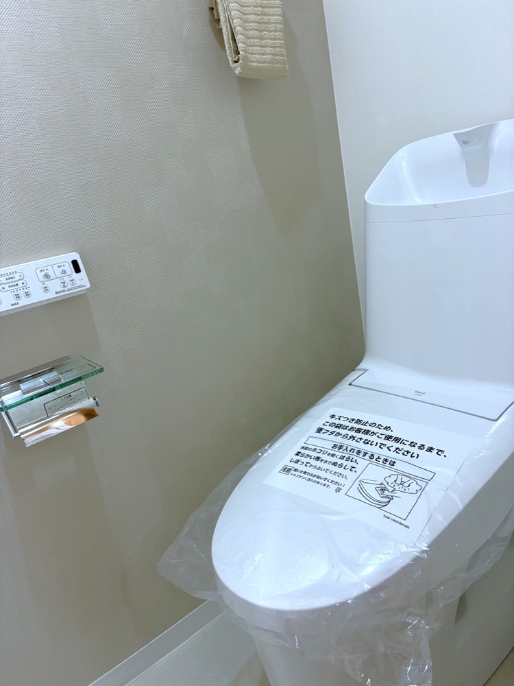 【トイレ】温水洗浄便座付きのトイレです。寒い時期でも暖かな便座で快適に使うことができます。リモコンが壁に設置され、操作しやすい仕様です。
