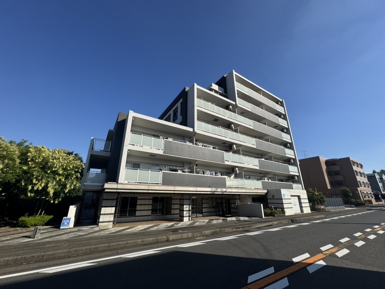 【現地外観写真】マンション前面には整備された歩道が続いており、お子様との歩行やベビーカーでの移動も安心です。周辺環境と併せて、現地をご見学ください。