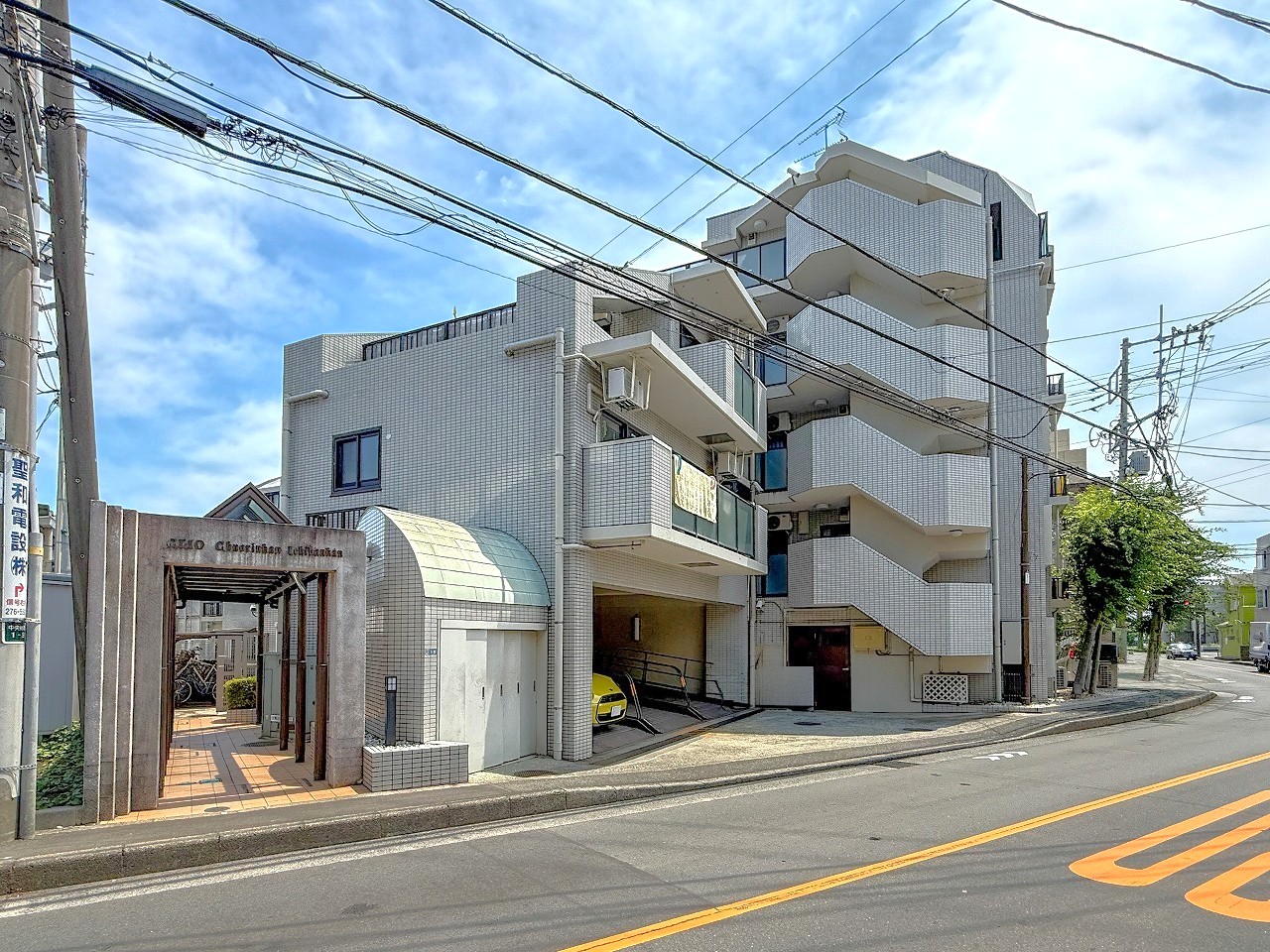 【現地外観】小学校まで徒歩8分と、子育て世帯にも嬉しい立地です。敷地内には、駐車場・駐輪場が設けられています。最新の空き状況や使用料は、お気軽にお問い合わせください。