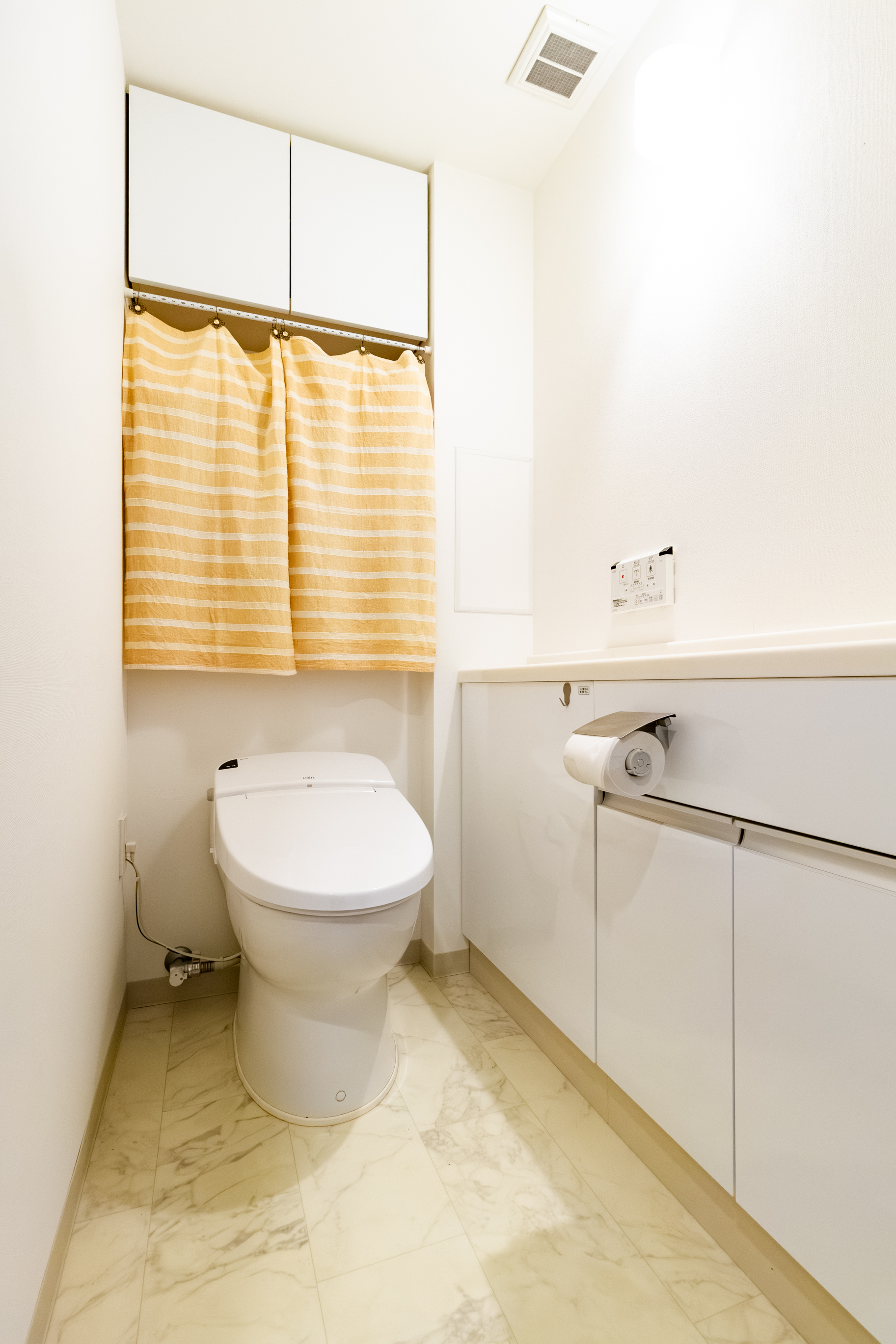 省エネ（超節水・調節電）でお手入れもしやすい高機能シャワートイレ。手洗い付きカウンターと吊戸棚でトイレットペーパーなどもしっかり収納できます。