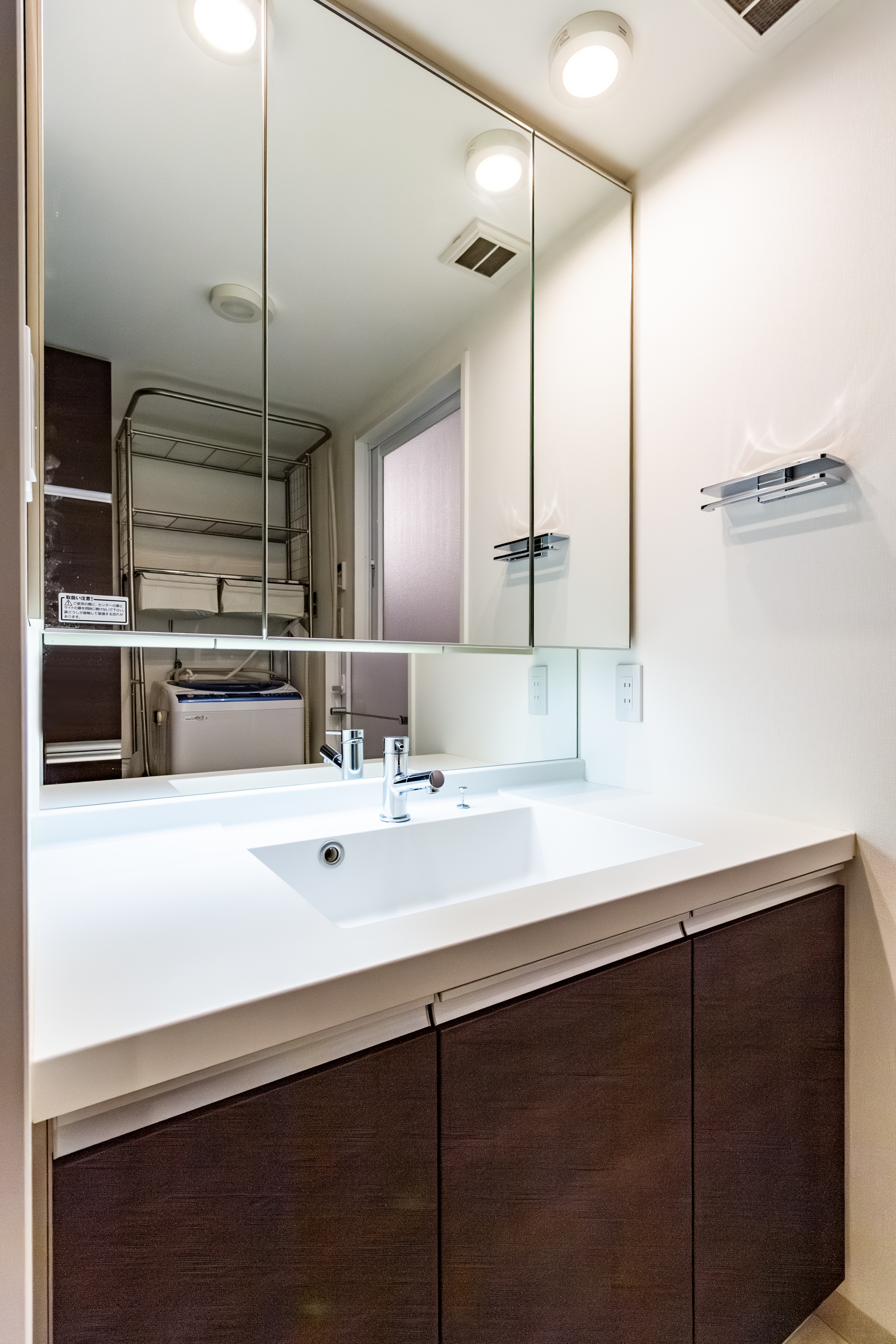 三面鏡洗面化粧台。鏡の裏も収納スペースになっているので化粧水などの収納にも適しています。