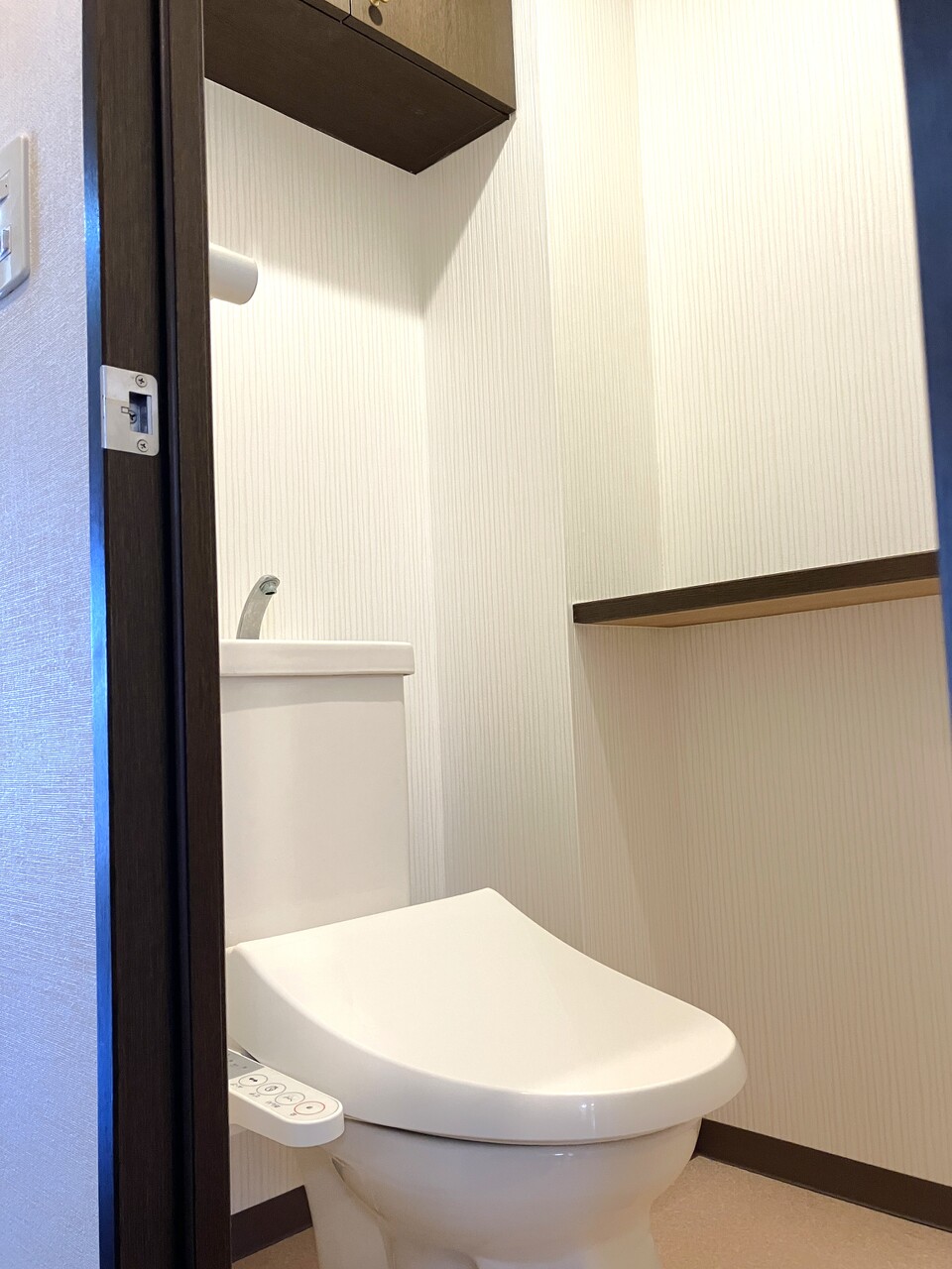 トイレは横にはフレグランスなどを置けるカウンター、上にはトイレットペーパなどを収納する棚があります。