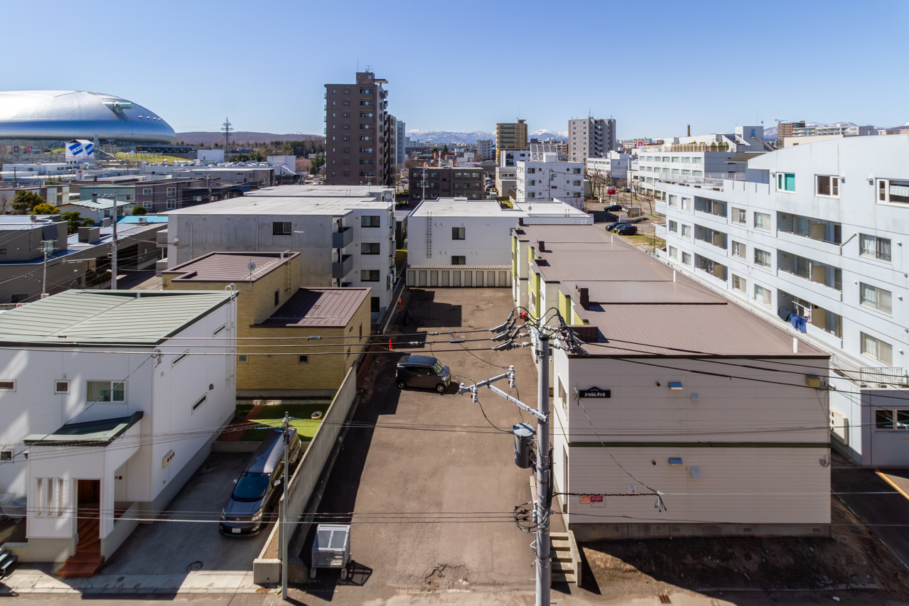 西側リビング側バルコニーからの眺望。左手には大和ハウスプレミストドーム、奥には山並みも見えます。