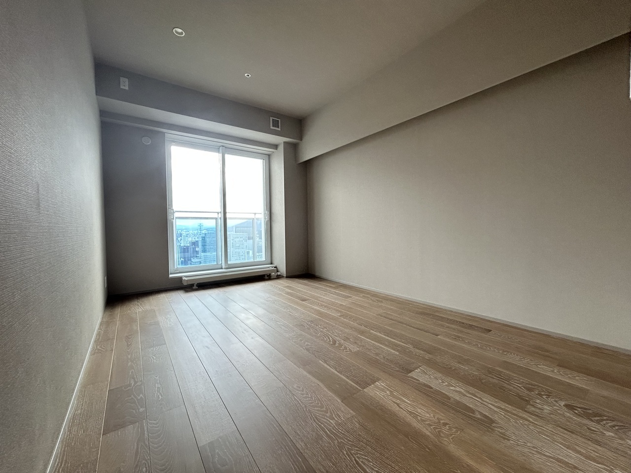 約9.1帖の洋室です。温かい雰囲気を持つ木目調の床は様々な種類の家具に合いやすい、シンプルなデザインです。