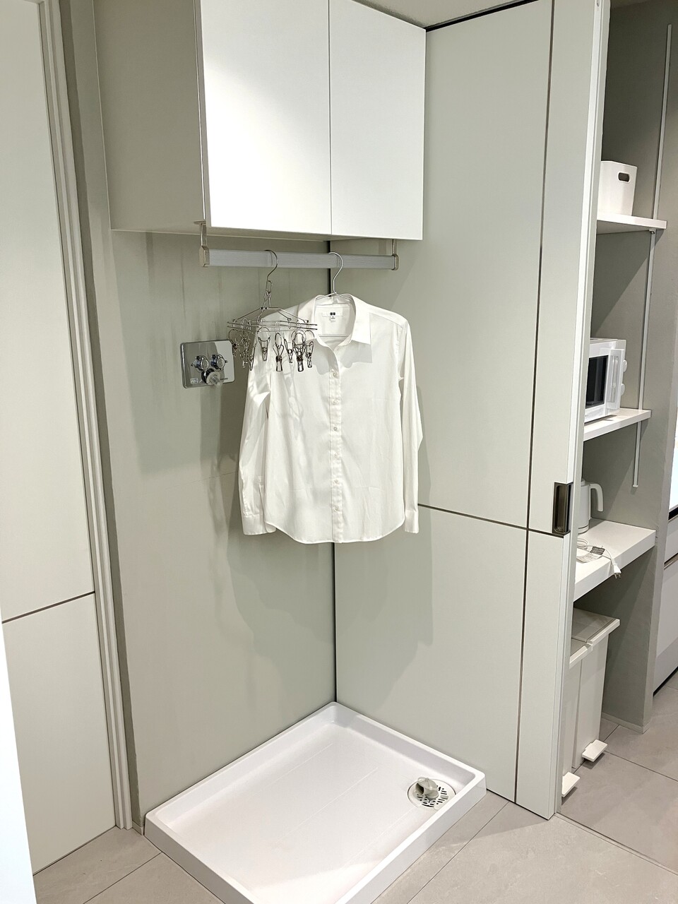 洗濯機置き場と上部の吊り収納。洗剤などの小物を収納することができます。