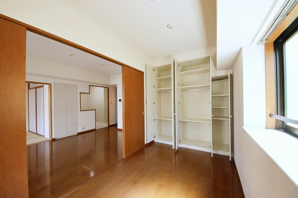 【洋室/約5.1帖】南側の窓からあたたかな陽光が注ぐ、明るい洋室。棚付きの収納スペースがあり、衣類や小物をすっきりと収納できます。