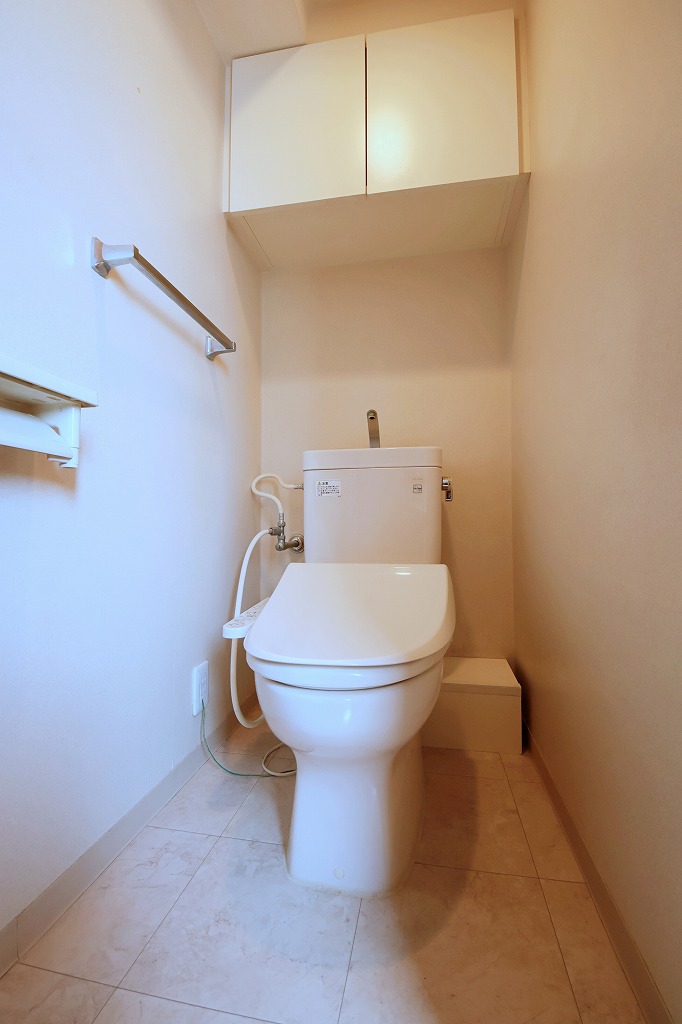 【トイレ】温水洗浄便座付きのトイレです。寒い時期でも温かな便座で快適に使うことができます。トイレットペーパーや掃除用具などの保管に便利な、吊り戸棚が設置されています。