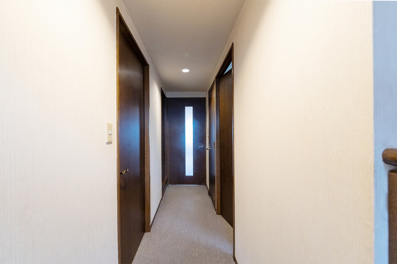 【廊下】玄関からLDKへ続く廊下です。ダークカラーの建具が空間にアクセントを添えています。