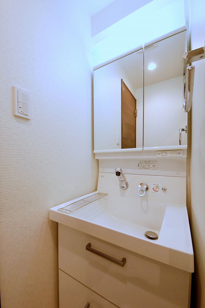 【洗面室】洗面化粧台は、水栓回りに水が溜まりにくい壁出しタイプ。下部にはスライド式の収納があり、奥の物まで取り出しやすく、洗面用品を効率よく収納できます。