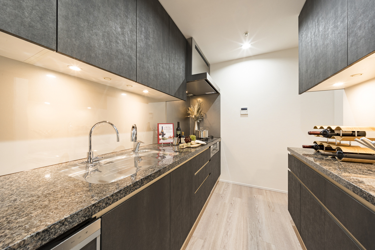 【キッチン】LDと対照的に、ダークトーンで纏められたスタイリッシュなデザイン。独立した配置で、急な来客にも慌てず対応できます。※家具・調度品等は販売価格に含みません。