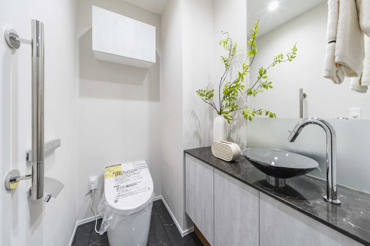 【トイレ】スタイリッシュなトイレ。手洗い器が備わっており、使用後すぐの手洗いが可能です。トイレットペーパーのストックに便利な収納付きです。※家具・調度品等は販売価格に含みません。