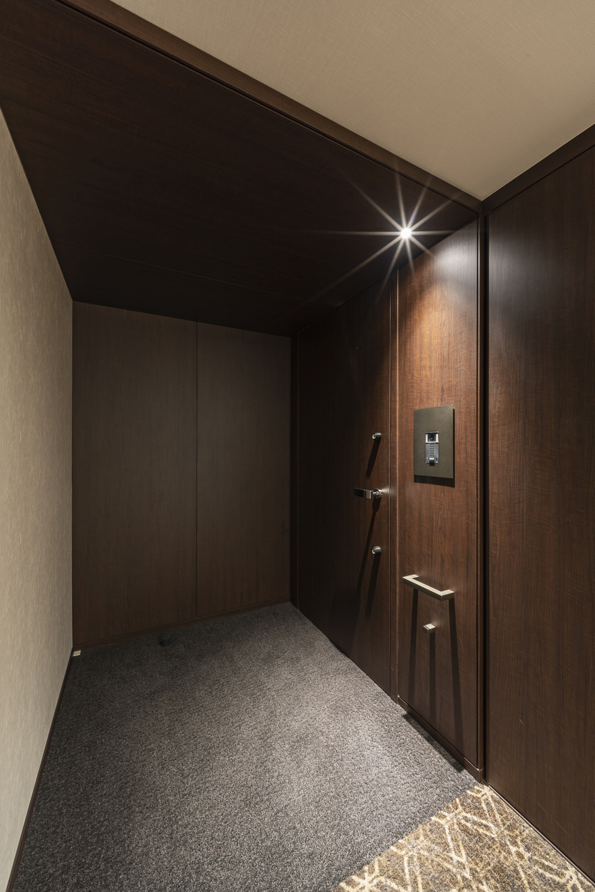 【玄関】ホテルライクな内廊下。玄関ドアは木目調で重厚感があります。玄関を入るとSICがあり、お履き物のほかにゴルフバッグや雨具・アウトドア用品などを保管していただけます。
