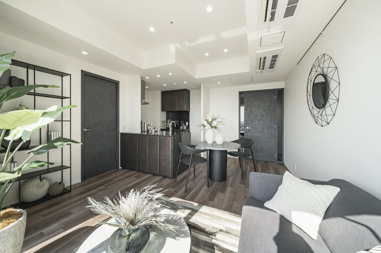 【LDK】ホワイトカラーのクロスにダークカラーの建具とフローリングが映え、落ち着きのある雰囲気を演出。お家時間をゆったりと過ごすことができます。※家具・調度品等は販売価格に含みません。