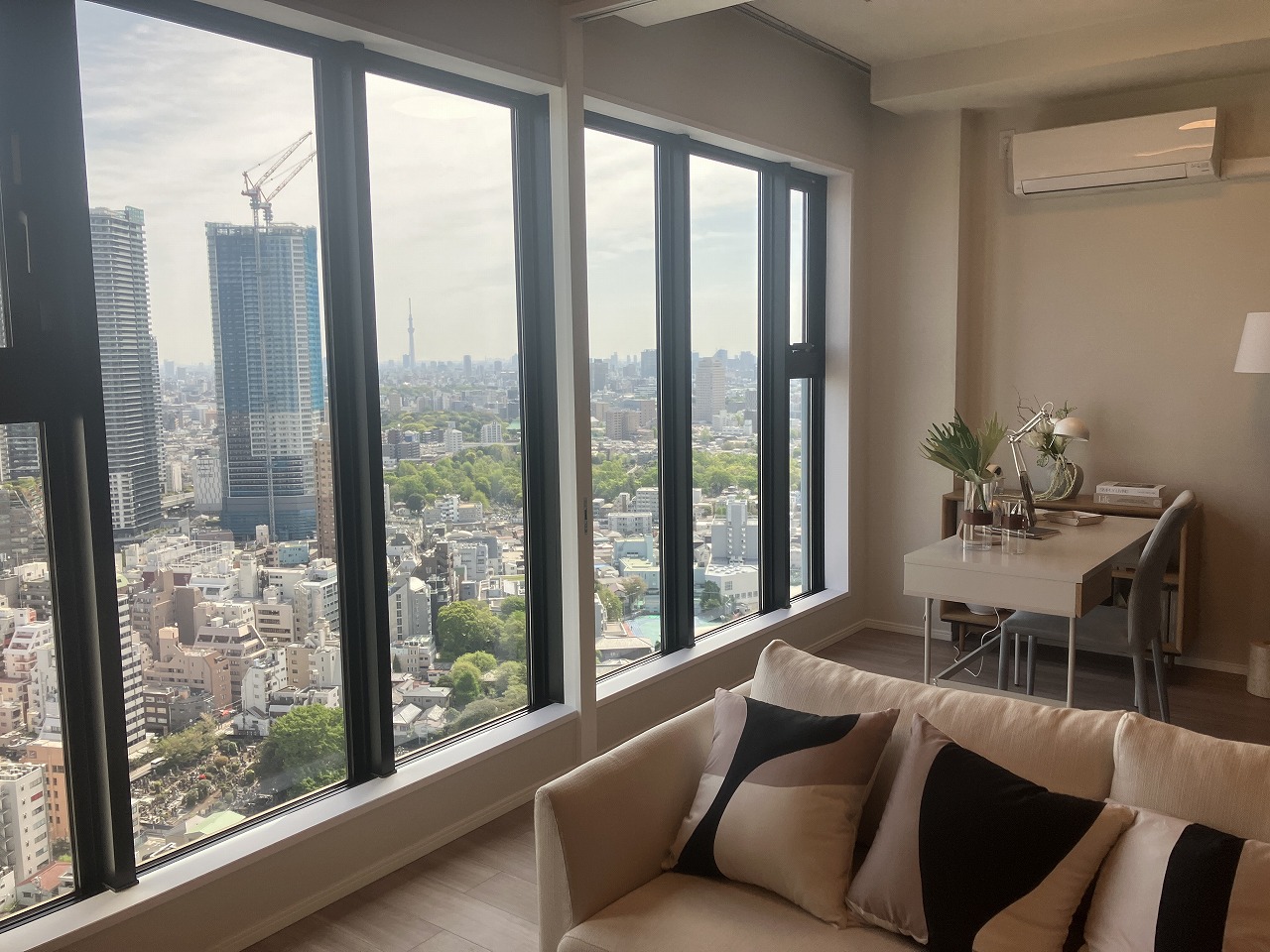 【LDK】大きな窓からやわらかな陽光が差し込み、室内に心地よい明るさが広がります。窓の向こうには都心の景色が広がり、開放感のある眺めを楽しめます。※家具・調度品等は販売価格に含みません。