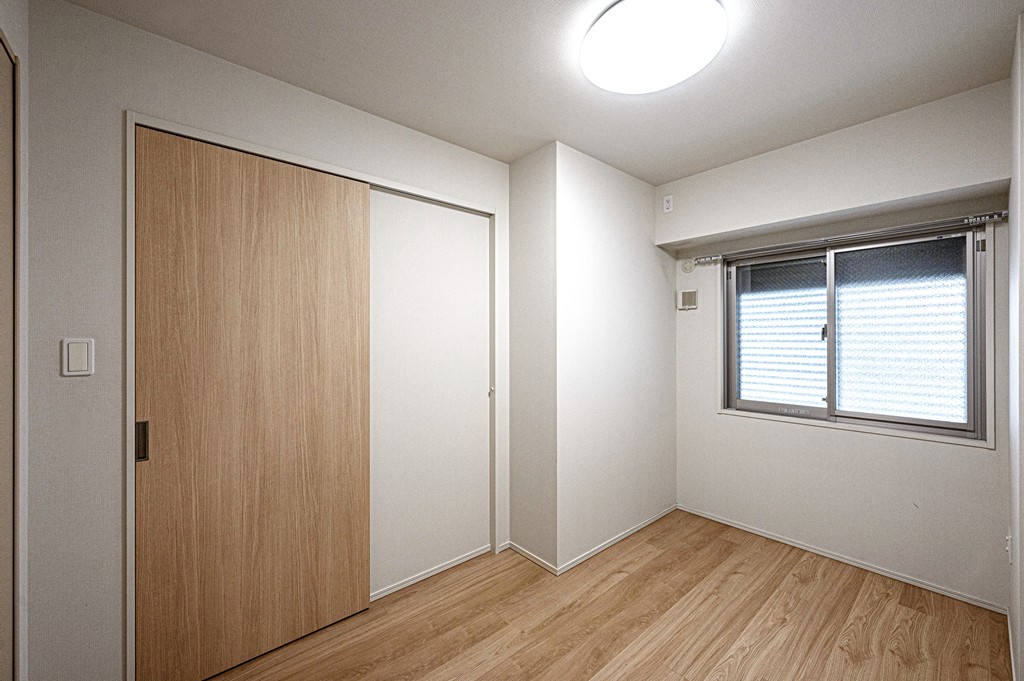 【洋室(北東側)/約5帖】腰高窓が採用されており、デスクやベッドなどの家具を壁付けで配置できます。出入り口扉は、引き戸が採用されています。