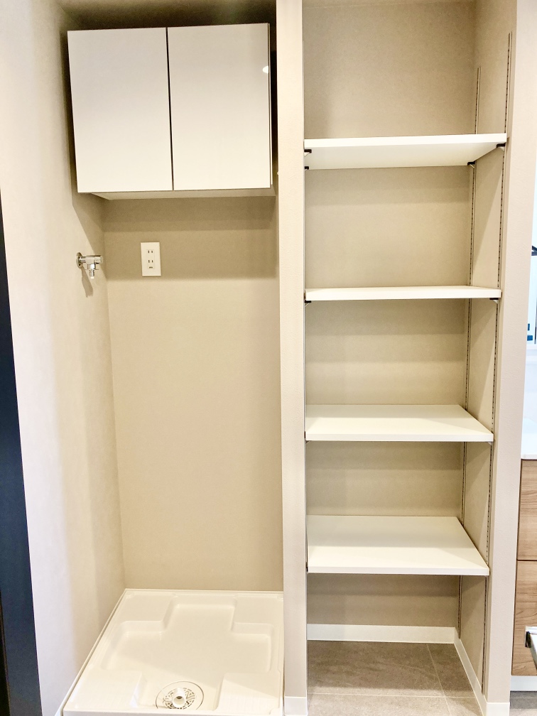 【洗面室】明るく清潔感のある洗面室です。洗面台と洗濯機置き場の間には可動式の棚が設置されており、置き場所を迷いがちなタオルや洗剤、パジャマなどもまとめて収納できます。