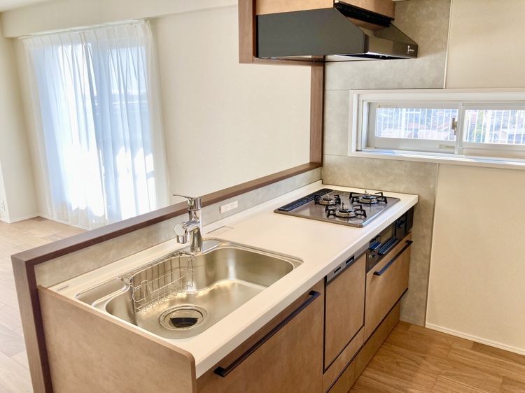 【キッチン】三口コンロとグリルが備わったシステムキッチン。家事負担を軽減する食洗機も搭載されています。食事後の家事の時短が叶い、ご家族との時間をゆっくりと過ごすことができます。