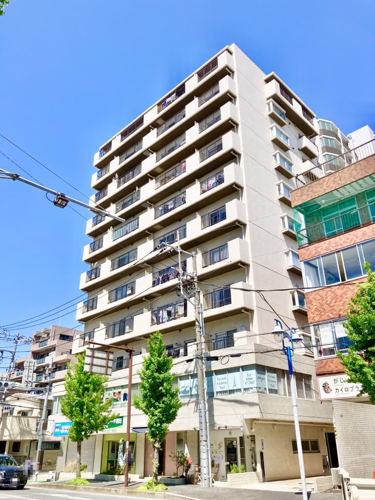 【現地外観写真】湘南の街並みに調和するホワイトタイル貼りの外観。2026年4月に内装リフォームが実施されている他、2020年1月に大規模修繕工事が完了済みです。