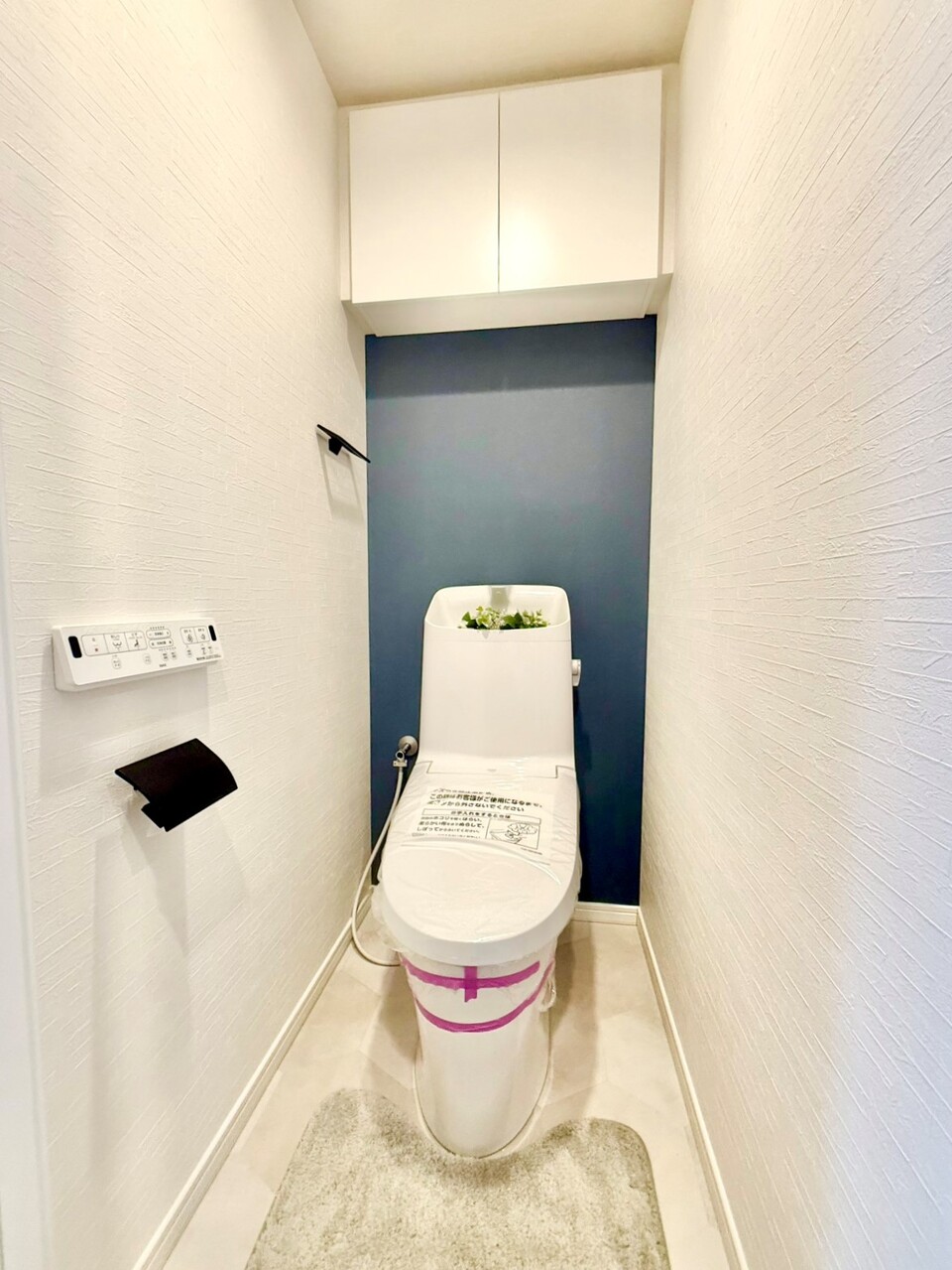 【トイレ】温水洗浄便座付きのトイレです。寒い時期でも暖かな便座で快適に使うことができます。リモコンが壁に設置され、操作しやすい仕様です。