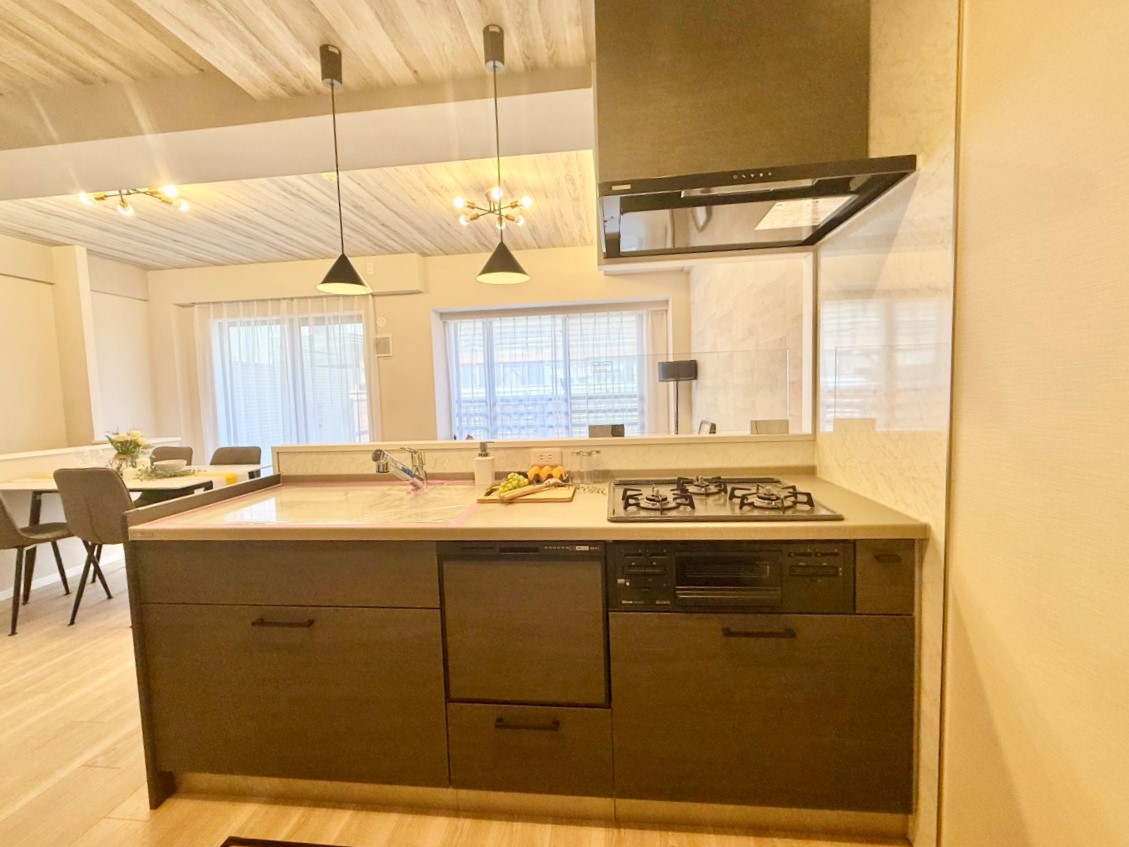 【キッチン】三口コンロとグリルが備わったシステムキッチン。家事負担を軽減する食洗機も搭載されています。食事後の家事の時短が叶い、ご家族との時間をゆっくりと過ごすことができます。