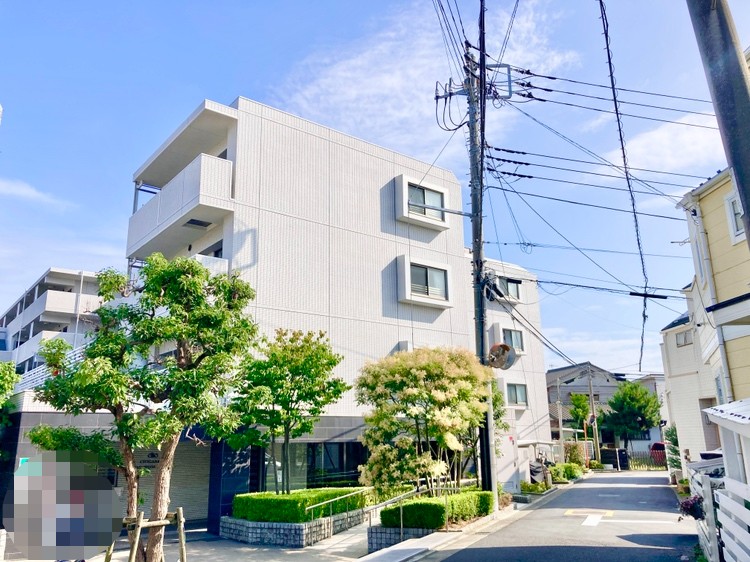 【現地外観】青空とのコントラストが印象的なホワイトの爽やかな外観。スロープが設置されており、ベビーカーやスーツケースの移動もスムーズです。