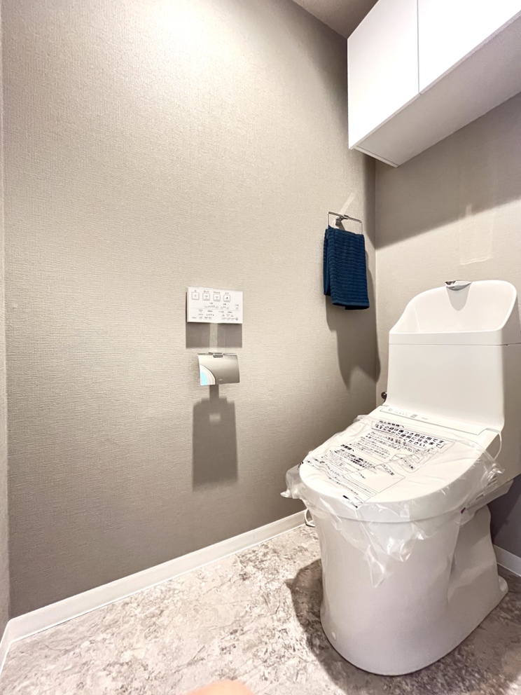 【トイレ】温水洗浄便座付きで、年間を通して快適にご使用いただけます。トイレットペーパーなどの収納に便利な吊戸棚付き。