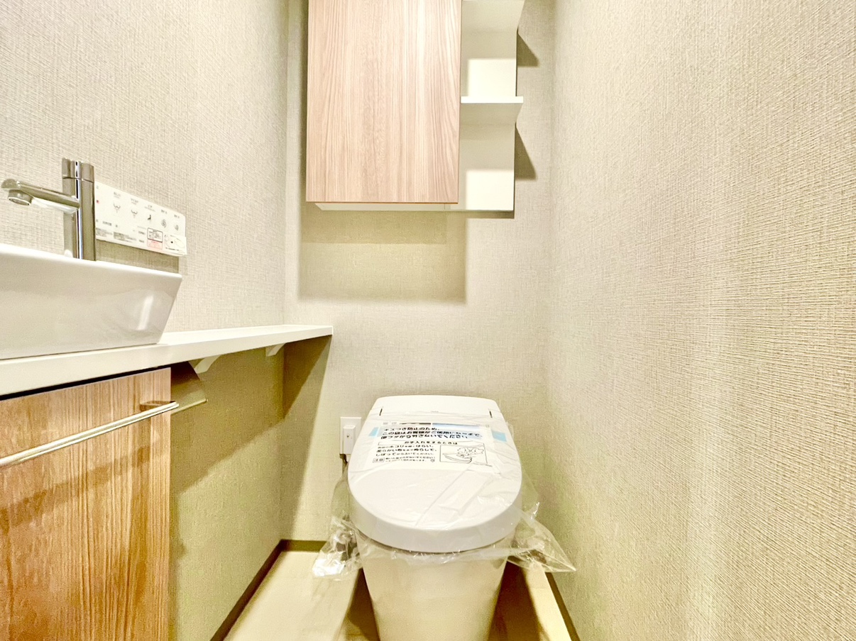 【トイレ】毎日清潔にご使用いただける、温水洗浄便座が設置されています。壁にリモコンが備え付けられているので、操作がしやすいとともに、便座周りの掃除もスムーズです。