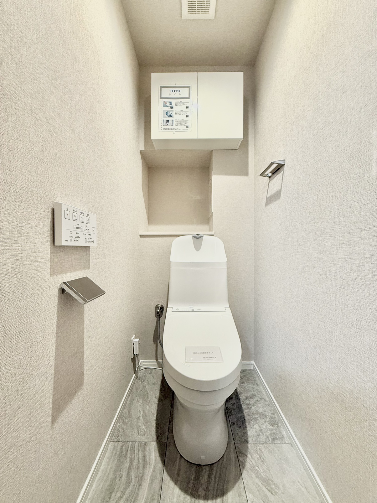 ホワイトを基調としたトイレは清潔感がございます。上部に棚があり、掃除用品の収納にも便利です。