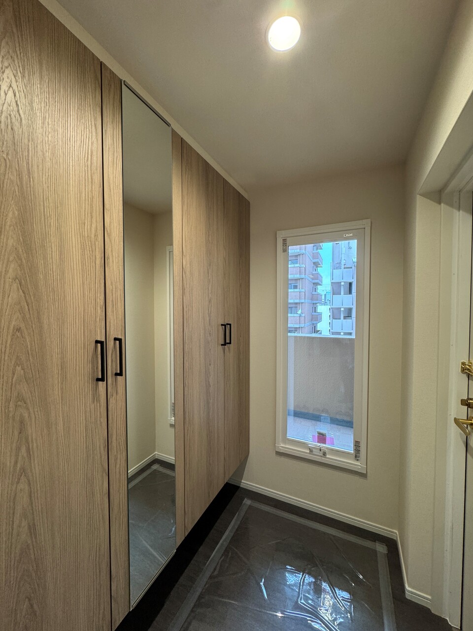 明るい光が差し込む、窓付きの玄関です。