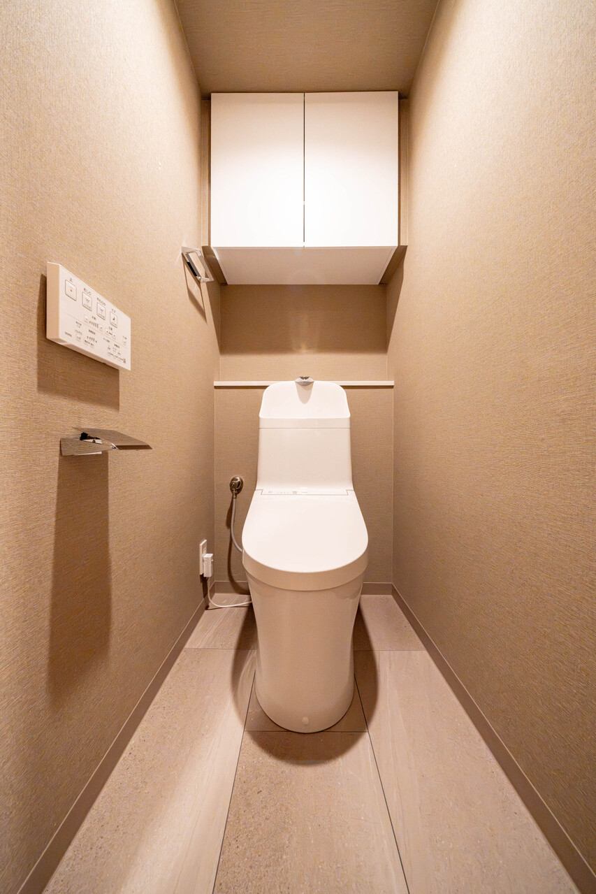 ホワイトを基調としたトイレは清潔感がございます。上部に棚があり、掃除用品の収納にも便利です。