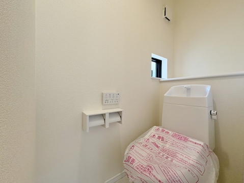 白を基調とした清潔感のあるトイレスペースです。手洗い一体型の多機能トイレを採用し、限られた空間を賢く活用。温かみのある木目調のフロアが落ち着いた雰囲気を醸し出し、毎日の生活に心地よさを提供します。