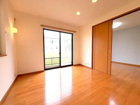 大きな窓から自然光が差し込む明るい洋室。引き戸を開放すれば隣室と繋げて広く使えます。