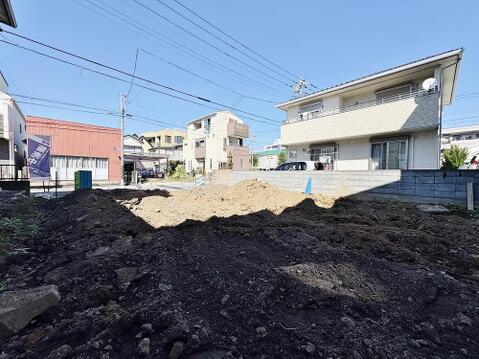 陽光降り注ぐ現地。周辺には穏やかな住宅が立ち並び、家族が安心して暮らせる環境が魅力です。夢のマイホームをここで実現しませんか。