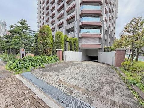 豊かな緑に囲まれた、洗練された外観のマンション。地下駐車場完備で、お子様との外出もスムーズです。家族の笑顔が育つ、安心の住まい。