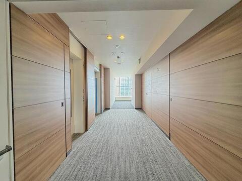光と木のぬくもりを感じる、ホテルライクな内廊下。プライバシーを守りながら、家族が安心して暮らせる洗練された空間です。