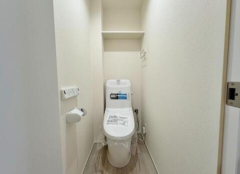 清潔感あふれるトイレは、家族みんなが毎日気持ちよく使える空間です。上部の棚には、トイレットペーパーや掃除用品をすっきり収納でき、機能性も兼ね備えています。