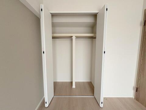 洋室５．２７帖　収納ハンガーパイプと上部棚を備えた開口部の広いクローゼットです衣類をかけて収納できるだけでなく、足元や棚上にもケースや小物を収められるため、室内をすっきり保てます