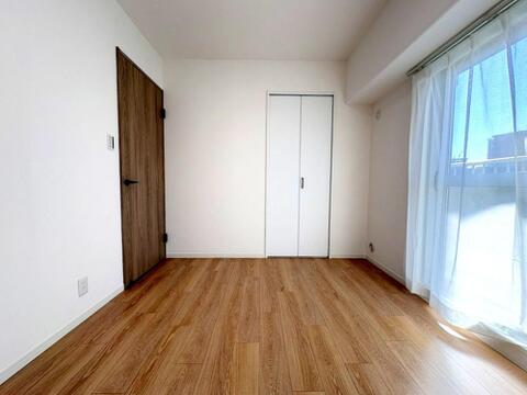 大きな窓から光が届く心地よい洋室。部屋の隅には可動式のオープン棚が備わっており、書籍の収納や観葉植物などを飾るディスプレイスペースとしても重宝します。