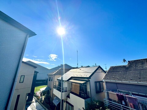 住宅街の屋根と周辺の街並みを望む眺望