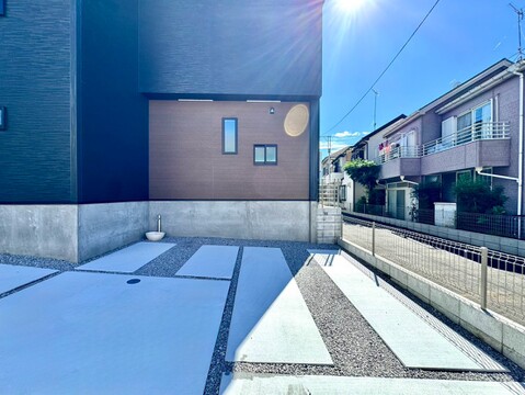 住宅街に面した戸建ての外観と前面道路