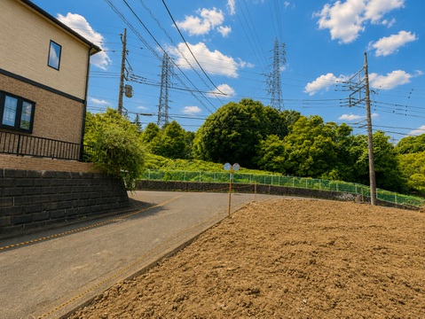 住宅近くの見晴らしの良い道路と畑の風景