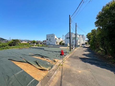 住宅街の道路沿いにある建築予定地の様子です