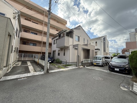 住宅街の中にある2階建ての住宅と駐車スペース