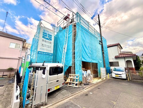 建設中の住宅外観、青い防護ネットが掛かっています